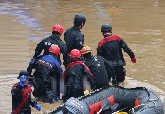 16일 미호천 제방 유실로 침수된 충북 청주시 오송읍 궁평2지하차도에서 119 구조대원들이 시신으로 발견된 실종자를 수습하고 있다. [청주=연합뉴스]